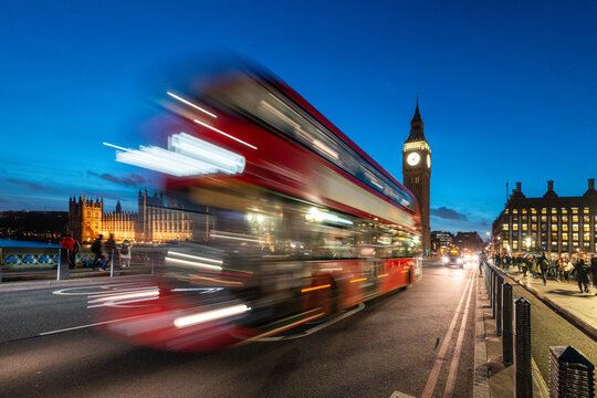 London street scene at night with red bus and Big Ben - Powered by Adobe