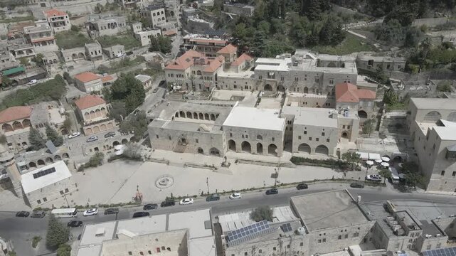 Aerial view of the historic main square in Deir el Qamar, Lebanon, surrounded by traditional stone buildings, houses, and cultural landmarks. 