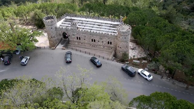 Aerial view of Moussa Castle, a famous historical landmark and museum located near Deir el Qamar, Lebanon, surrounded by forested mountains. 