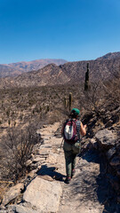 Young woman hiking in an arid valley in northern Argentina. Taken in a warm spring morning under a blue sky