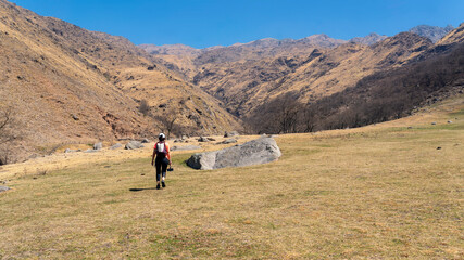 young woman hiking in a mountain area located in Tafi del Valle, Tucuman. in a spring warm morning