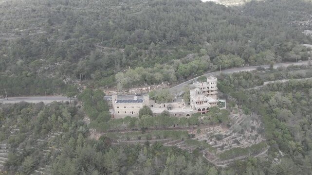Aerial view of Moussa Castle, a famous historical landmark and museum located near Deir el Qamar, Lebanon, surrounded by forested mountains. 