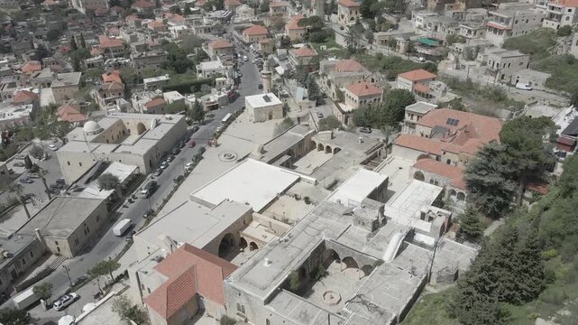 Aerial view of the historic main square in Deir el Qamar, Lebanon, surrounded by traditional stone buildings, houses, and cultural landmarks. 