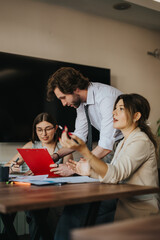 Group of coworkers engaged in an interactive discussion reviewing documents in a workspace setting