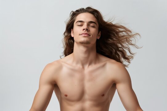 young man with long hair in a relaxed meditative pose eyes closed with a calm expression shirtless against a neutral background capturing a moment of tranquility and peace