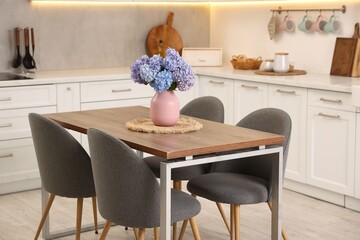 Dining table, chairs and floral decor in kitchen. Interior design