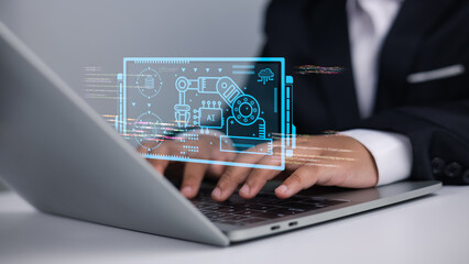 Business professional using laptop with futuristic holographic AI and robotics automation interface for digital transformation and industry 4.0