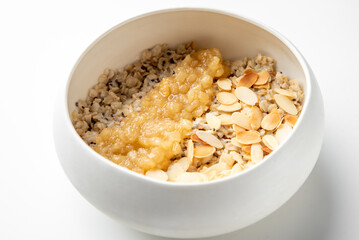 Healthy breakfast bowl with oatmeal, mashed banana, and toasted almonds. Nutritious vegan meal rich in fiber, perfect for clean eating and balanced diet concepts.