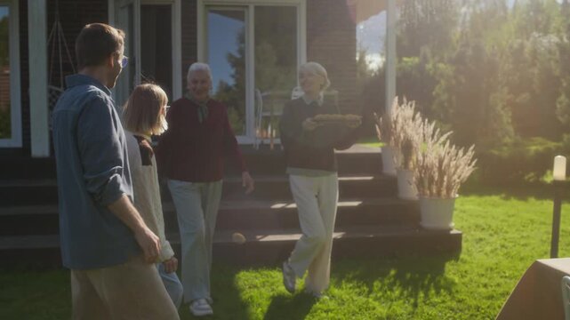 Slowmo shot of happy middle-aged Caucasian mother serving dish at festive table outdoors on sunny autumn day in cozy backyard prepared for warm family gathering