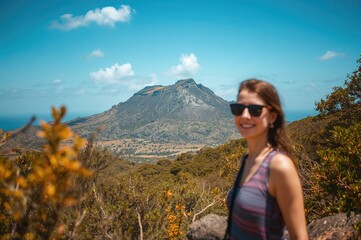 Naklejka premium Scenic view from volcanic rock formation with a woman in sunglasses enjoying the landscape on Gran Canaria under a clear blue sky with clouds