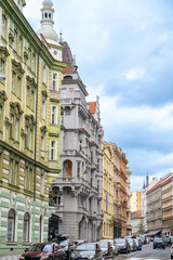 Obraz premium Prague, Czech Republic, August 7, 2023. Street view of the riverside promenade, with beautiful period houses with colorful facades overlooking the Vltava River. Vertical format.