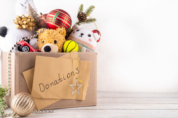 Donating gifts and toys to charity for Christmas holiday concept. Tradition holiday toys drive, cardboard box full with with kids toys, gifts, Christmas decorations, baubles and sweets, copy space © ricka_kinamoto