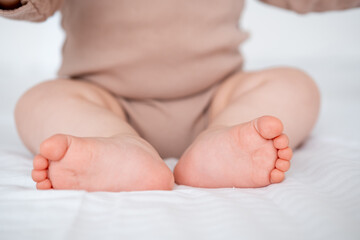 baby's legs on a white bed, a place for text