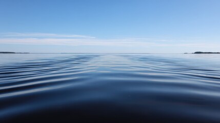 Obraz premium Symmetrical Calm Serene Lake Surface Subtle Ripples Clear Blue Sky Background - Tranquil Natural Landscape