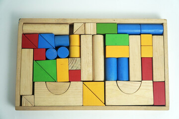 A vintage wooden box filled with a variety of building blocks in different shapes and colors. This image is perfect for concepts of childhood, learning, games, and retro toys.

