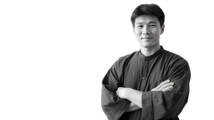 Asian Man in a Portrait: A serene Asian man with arms crossed looks directly at the viewer in a studio portrait, expressing confidence and approachability.