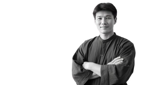 Asian Man in a Portrait: A serene Asian man with arms crossed looks directly at the viewer in a studio portrait, expressing confidence and approachability.