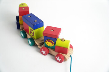 A colorful wooden toy train with blocks of different shapes and numbers, isolated against a white background. This image is perfect for concepts of childhood, learning, games, and vintage toys.


