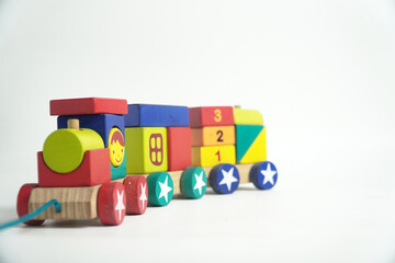 A colorful wooden toy train with blocks of different shapes and numbers, isolated against a white background. This image is perfect for concepts of childhood, learning, games, and vintage toys.

