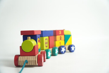 A colorful wooden toy train with blocks of different shapes and numbers, isolated against a white background. This image is perfect for concepts of childhood, learning, games, and vintage toys.

