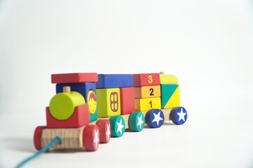 A colorful wooden toy train with blocks of different shapes and numbers, isolated against a white background. This image is perfect for concepts of childhood, learning, games, and vintage toys.


