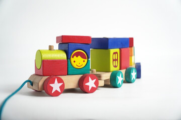 A colorful wooden toy train with blocks of different shapes and numbers, isolated against a white background. This image is perfect for concepts of childhood, learning, games, and vintage toys.

