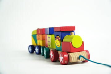 A colorful wooden toy train with blocks of different shapes and numbers, isolated against a white background. This image is perfect for concepts of childhood, learning, games, and vintage toys.

