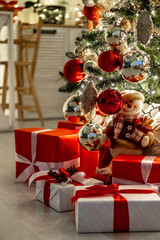 a Christmas tree with a New Year decor with red balls and gifts under it, a New Year's festive atmosphere at home