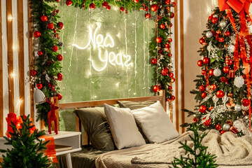 New Year's interior of the house in the bedroom with red, yellow, green decor, a bed near the Christmas tree, a New Year's festive atmosphere in the apartment
