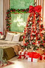 New Year's interior of the house in the bedroom with red, yellow, green decor, a bed near the Christmas tree, a New Year's festive atmosphere in the apartment