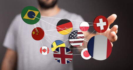 A human hand holding a network of various country flags representing global connection,...