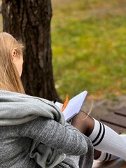 woman writes on a notebook in an autumn park