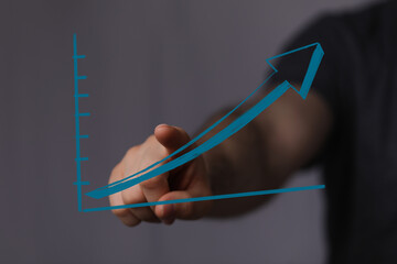 Hand touching a graph with an arrow pointing up, symbolizing progress, success, financial growth,...