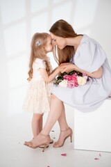 mom with a baby little daughter with peony flowers on a white isolated background, space and room for text