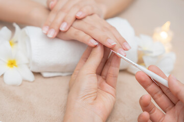 Woman receive care service by professional Beautician Manicure at spa centre. Nail beauty salon use nail file for Glazing treatment. manicurist make nail customer to beautiful. body care spa treatment