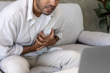 hand hold chest with heart attack symptoms, asian man have chest pain caused by heart disease, leak, dilatation, enlarged coronary heart, press on the chest with a painful expression