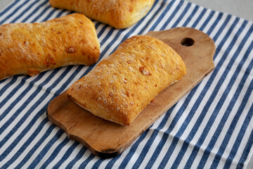Homemade Cheese Ciabatta Bread on a Wooden Board, side view.