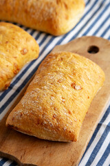 Homemade Cheese Ciabatta Bread on a Wooden Board, side view.