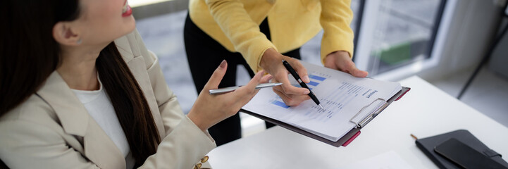 Asian adult business women collaborate discuss financial report analyze data project planning corporate strategy office workspace