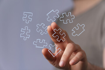 Hand connecting puzzle pieces, symbolizing problem-solving, strategy, and teamwork. Ideal for business, technology, and education.