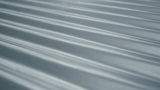 Corrugated Metal Roofing Texture - A close-up shot of a shiny, corrugated metal surface. The video showcases the texture and pattern of the steel sheet, creating a sense of depth and dimension.