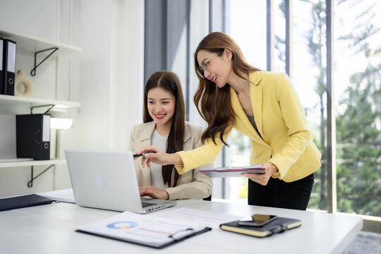 Asian business women professionals discuss project data on laptop planning strategy in modern office collaboration - Powered by Adobe