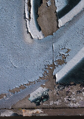 cracked and peeling paint on a wall surface. The weathered texture shows layers of faded blue and white paint flaking off, revealing an aged and distressed background. Perfect as a grunge overlay.