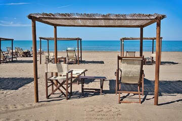 Beach resort with straw umbrellas and deck chairs, Marina di Castagneto Carducci, Tuscany, Italy