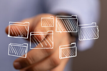 A hand points towards drawn folders, symbolizing data storage, cloud computing, and online...