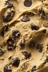 Close Up of Fresh Raw Cookie Dough with Creamy Texture and Brown Sugar Specks on Wooden Spoon and Chopping Board