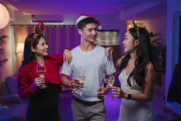 Asian friends celebrating christmas party drinking wine together