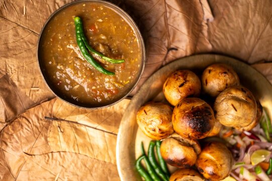 Litti Chokha is Bihar&rsquo;s signature dish made with roasted wheat balls stuffed with spiced sattu, served with mashed potato, brinjal, and tomato. It reflects Bihar&rsquo;s rustic flavors and culinary heritage