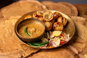 Litti Chokha is Bihar’s signature dish made with roasted wheat balls stuffed with spiced sattu, served with mashed potato, brinjal, and tomato. It reflects Bihar’s rustic flavors and culinary heritage