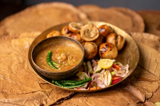 Litti Chokha is Bihar&rsquo;s signature dish made with roasted wheat balls stuffed with spiced sattu, served with mashed potato, brinjal, and tomato. It reflects Bihar&rsquo;s rustic flavors and culinary heritage